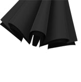 A zoomed in photo of the black canopy of an umbrella that is collapsed but not tied down securely.